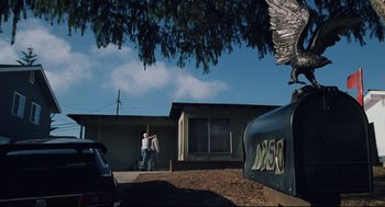 Movie still from “Brick” (2005), directed by Rian Johnson – Two people are walking in front of a house; Extreme Wide shot, Low angle