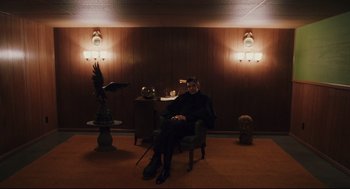 Movie still from “Brick” (2005), directed by Rian Johnson – A person sitting in a chair in a room; Wide shot, Low angle