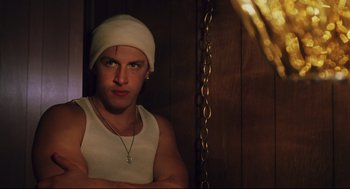 Movie still from “Brick” (2005), directed by Rian Johnson – A young man wearing a white hat and a white tank top; Medium shot, Low angle