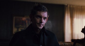 Movie still from “Brick” (2005), directed by Rian Johnson – A man in a black shirt and black jacket; Close Up shot, Over the shoulder angle