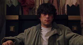 Movie still from “Brick” (2005), directed by Rian Johnson – A young man sitting in front of a wall; Close Up shot, Low angle