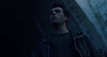 Movie still from “Brick” (2005), directed by Rian Johnson – A man in a leather jacket looking up at the sky; Close Up shot, Low angle