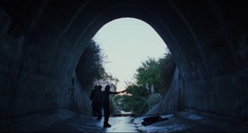 Movie still from “Brick” (2005), directed by Rian Johnson – A group of skateboarders riding through a tunnel; Wide shot, Low angle