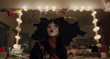 Movie still from “Brick” (2005), directed by Rian Johnson – A person with a mask on in front of a mirror; Medium shot, Low angle