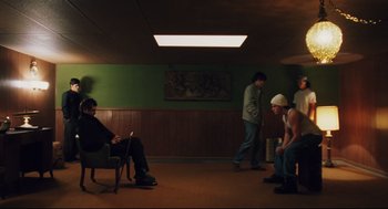 Movie still from “Brick” (2005), directed by Rian Johnson – A group of men standing in a room; Wide shot, High angle
