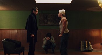 Movie still from “Brick” (2005), directed by Rian Johnson – A group of people standing around in a room; Medium shot, Low angle