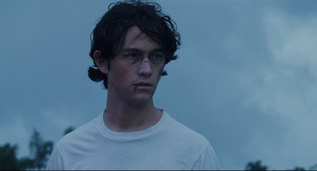 Movie still from “Brick” (2005), directed by Rian Johnson – A young man wearing glasses and a white t - shirt; Close Up shot, Over the shoulder angle