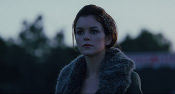 Movie still from “Brick” (2005), directed by Rian Johnson – A young woman wearing a fur coat looking at the camera; Close Up shot, Low angle
