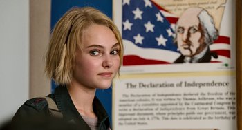 Movie still from “Bridge to Terabithia” (2007), directed by Gabor Csupo – A young woman standing in front of an american flag and declaration of independence; Close Up shot, Over the shoulder angle