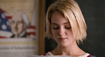 Movie still from “Bridge to Terabithia” (2007), directed by Gabor Csupo – A young woman with blonde hair is looking down at a piece of paper; Close Up shot, Over the shoulder angle