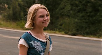 Movie still from “Bridge to Terabithia” (2007), directed by Gabor Csupo – A young girl with blonde hair is standing on the side of the road; Medium shot, Over the shoulder angle