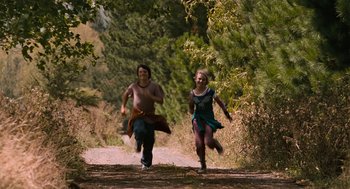 Movie still from “Bridge to Terabithia” (2007), directed by Gabor Csupo – A man and a woman running down a dirt road; Wide shot, High angle