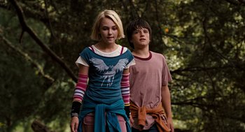 Movie still from “Bridge to Terabithia” (2007), directed by Gabor Csupo – A girl and a boy standing next to each other in front of a tree; Medium shot, Low angle