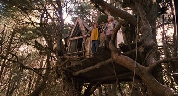 Movie still from “Bridge to Terabithia” (2007), directed by Gabor Csupo – Two people standing in a tree house on top of a tree; Wide shot, Low angle