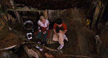Movie still from “Bridge to Terabithia” (2007), directed by Gabor Csupo – A man and a woman sitting on the ground; Wide shot, Overhead angle