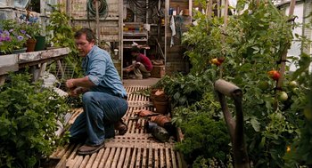 Movie still from “Bridge to Terabithia” (2007), directed by Gabor Csupo – A man kneeling down on the ground in a garden; Wide shot, Low angle