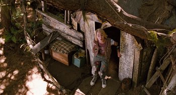 Movie still from “Bridge to Terabithia” (2007), directed by Gabor Csupo – A young girl standing in front of an old wooden structure; Wide shot, High angle