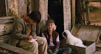 Movie still from “Bridge to Terabithia” (2007), directed by Gabor Csupo – Two young people sitting next to each other with a dog; Medium shot, Over the shoulder angle