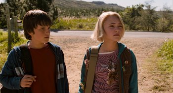 Movie still from “Bridge to Terabithia” (2007), directed by Gabor Csupo – Two young people standing in the dirt near a road; Medium shot, Over the shoulder angle