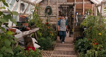 Movie still from “Bridge to Terabithia” (2007), directed by Gabor Csupo – A young boy walking down a path in a greenhouse; Wide shot, High angle