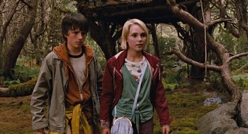 Movie still from “Bridge to Terabithia” (2007), directed by Gabor Csupo – A young man and a young woman standing next to each other in the woods; Medium shot, Low angle