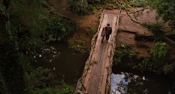 Movie still from “Bridge to Terabithia” (2007), directed by Gabor Csupo – Two people walking across a wooden bridge over a river; Extreme Wide shot, Overhead angle