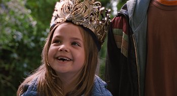 Movie still from “Bridge to Terabithia” (2007), directed by Gabor Csupo – A little girl wearing a crown and smiling for the camera; Close Up shot, Over the shoulder angle