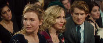 Movie still from “Bridget Jones's Baby” (2016), directed by Sharon Maguire – Two women are sitting in a crowd of people; Close Up shot, Over the shoulder angle