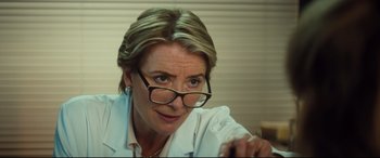 Movie still from “Bridget Jones's Baby” (2016), directed by Sharon Maguire – A person wearing glasses and a lab coat; Close Up shot, Over the shoulder angle