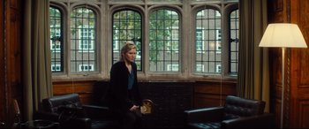 Movie still from “Bridget Jones's Baby” (2016), directed by Sharon Maguire – A woman sitting on a bench in front of a window; Wide shot, Over the shoulder angle