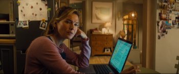 Movie still from “Bridget Jones's Baby” (2016), directed by Sharon Maguire – A woman sitting in front of a laptop computer; Medium shot, Over the shoulder angle