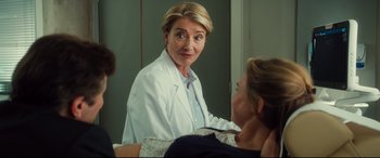 Movie still from “Bridget Jones's Baby” (2016), directed by Sharon Maguire – A woman in a white lab coat talking to another woman in front of a mirror; Medium shot, Over the shoulder angle