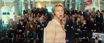 Movie still from “Bridget Jones's Baby” (2016), directed by Sharon Maguire – A woman wearing a headset in front of an audience; Medium shot, Over the shoulder angle