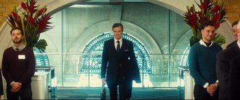 Movie still from “Bridget Jones's Baby” (2016), directed by Sharon Maguire – A man in a suit and tie holding a briefcase; Medium shot, Low angle