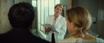 Movie still from “Bridget Jones's Baby” (2016), directed by Sharon Maguire – A woman in a white lab coat is holding a book; Medium shot, Over the shoulder angle