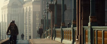 A woman walking down a sidewalk near a row of buildings