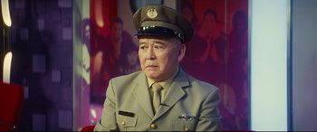 Movie still from “Bridget Jones's Baby” (2016), directed by Sharon Maguire – A man in a military uniform is sitting in front of a picture; Medium shot, Low angle