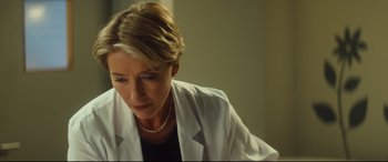 Movie still from “Bridget Jones's Baby” (2016), directed by Sharon Maguire – A woman wearing a white lab coat looking down; Close Up shot, Over the shoulder angle