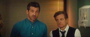 Movie still from “Bridget Jones's Baby” (2016), directed by Sharon Maguire – Two men standing next to each other in front of a wall; Close Up shot, Over the shoulder angle