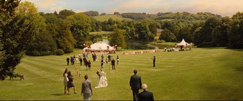 Movie still from “Bridget Jones's Baby” (2016), directed by Sharon Maguire – A group of people standing in the grass near a lake; Extreme Wide shot, High angle