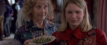 Movie still from “Bridget Jones's Diary” (2001), directed by Sharon Maguire – A woman holding a plate of food next to another woman; Close Up shot, High angle