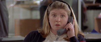 Movie still from “Bridget Jones's Diary” (2001), directed by Sharon Maguire – A woman wearing headphones while talking on a phone; Close Up shot, High angle