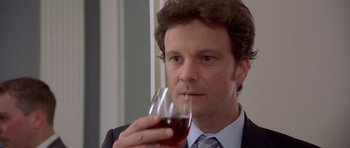 Movie still from “Bridget Jones's Diary” (2001), directed by Sharon Maguire – A person holding a glass of red wine; Close Up shot, Over the shoulder angle