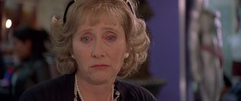 Movie still from “Bridget Jones's Diary” (2001), directed by Sharon Maguire – An older woman wearing a black jacket and pearls; Close Up shot, Over the shoulder angle