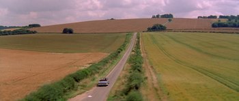 Movie still from “Bridget Jones's Diary” (2001), directed by Sharon Maguire – A car driving down a road in the middle of a field; Extreme Wide shot, High angle