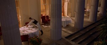 Movie still from “Bridget Jones's Diary” (2001), directed by Sharon Maguire – A person standing in front of a table with plates on top of it; Extreme Wide shot, High angle