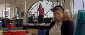 Movie still from “Bridget Jones's Diary” (2001), directed by Sharon Maguire – A woman sitting at a desk in front of a window; Medium shot, Over the shoulder angle