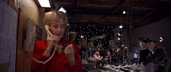 Movie still from “Bridget Jones's Diary” (2001), directed by Sharon Maguire – A woman talking on a phone while holding a flower; Medium shot, High angle