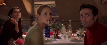 Movie still from “Bridget Jones's Diary” (2001), directed by Sharon Maguire – A woman sitting at a dinner table drinking a beverage; Close Up shot, Over the shoulder angle