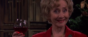 Movie still from “Bridget Jones's Diary” (2001), directed by Sharon Maguire – An older woman holding a glass of red wine; Close Up shot, Over the shoulder angle